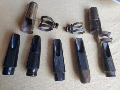 pile of vintage Saxophone mouthpieces, ligatures and caps